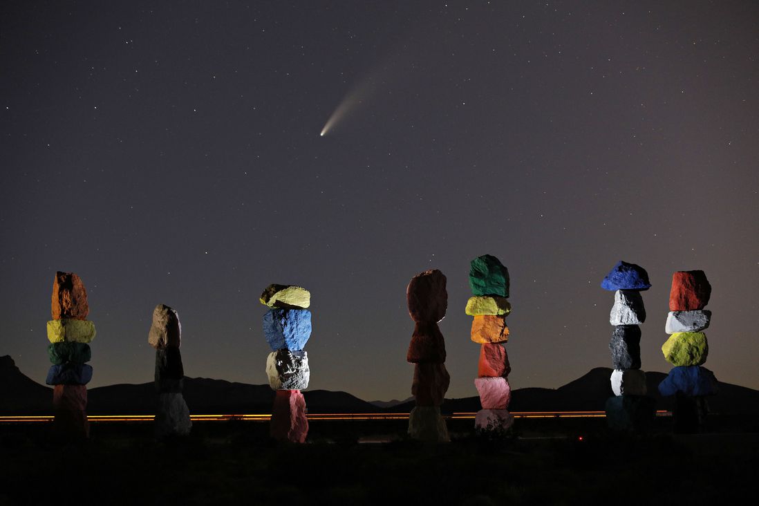 The comet Neowise, or C/2020 F3, is seen in the evening sky above "Seven Magic Mountains" by artist Ugo Rondinone, south of Las Vegas